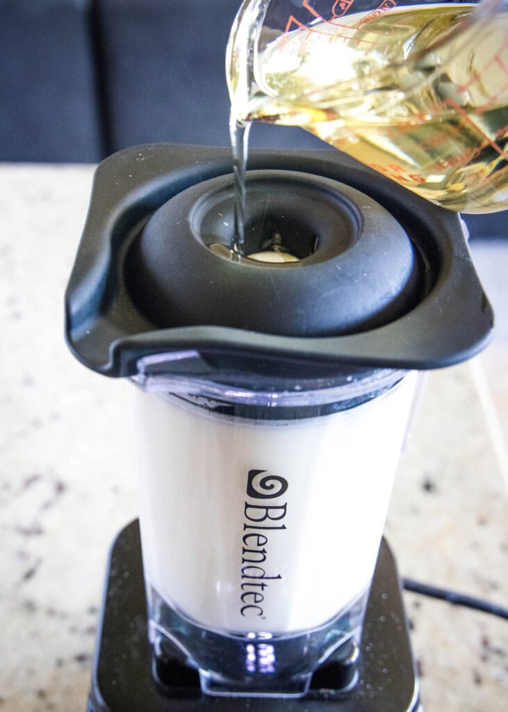 pouring oil in blender to make dressing