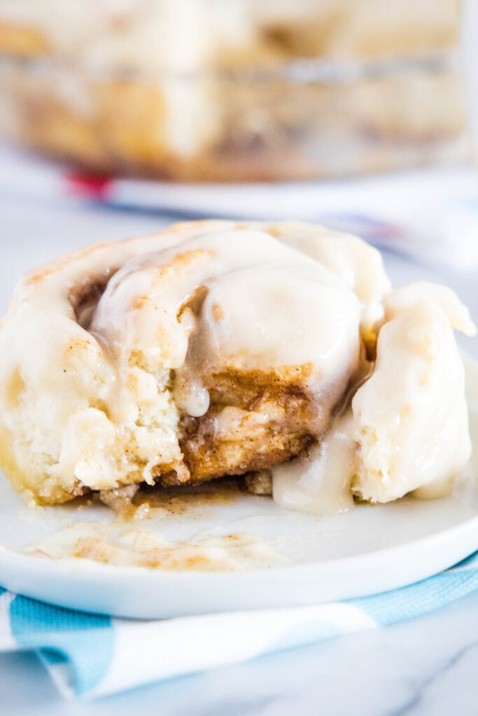 cinnamon roll on a plate with bite missing