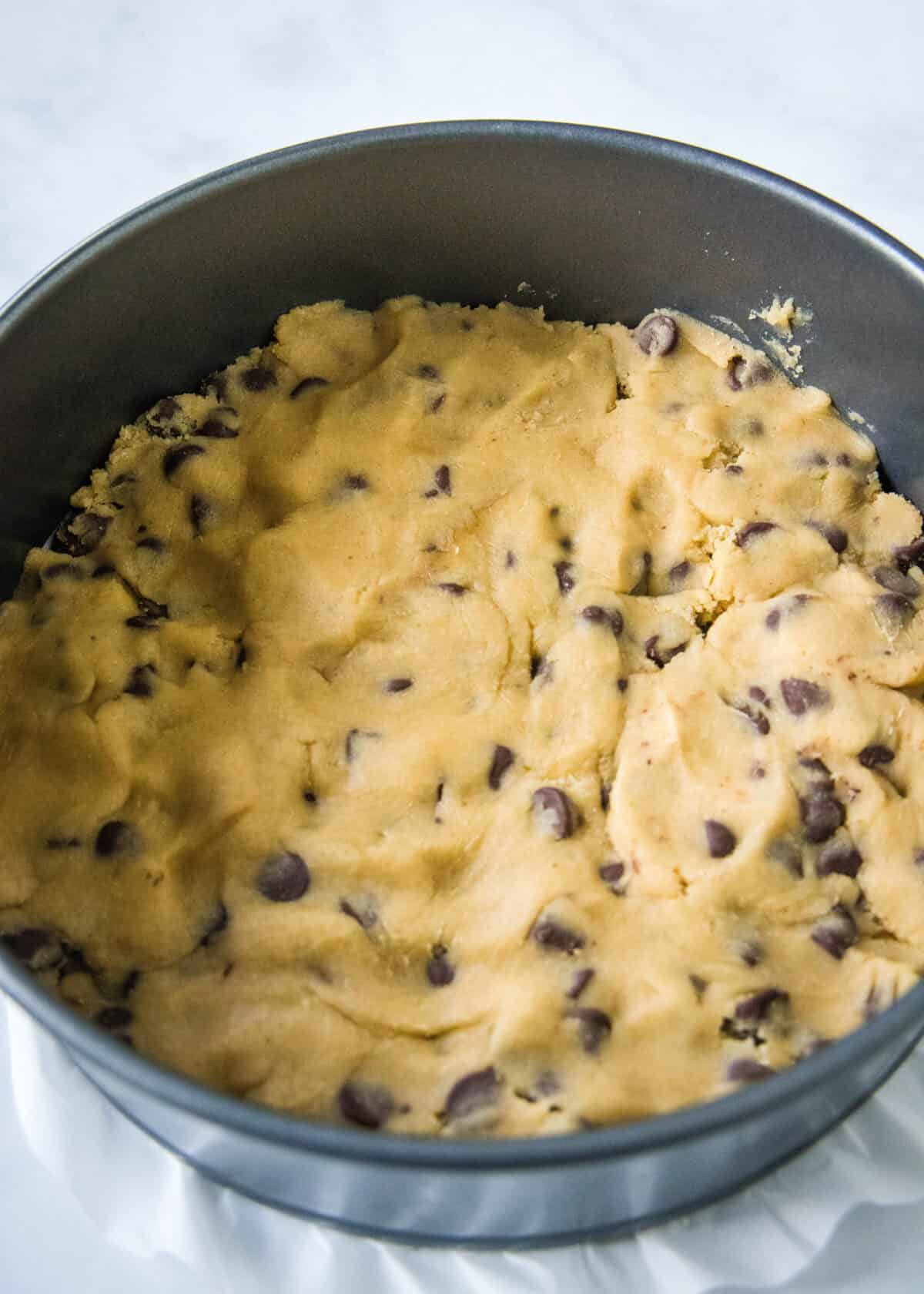 cookie dough pressed into a spring form pan