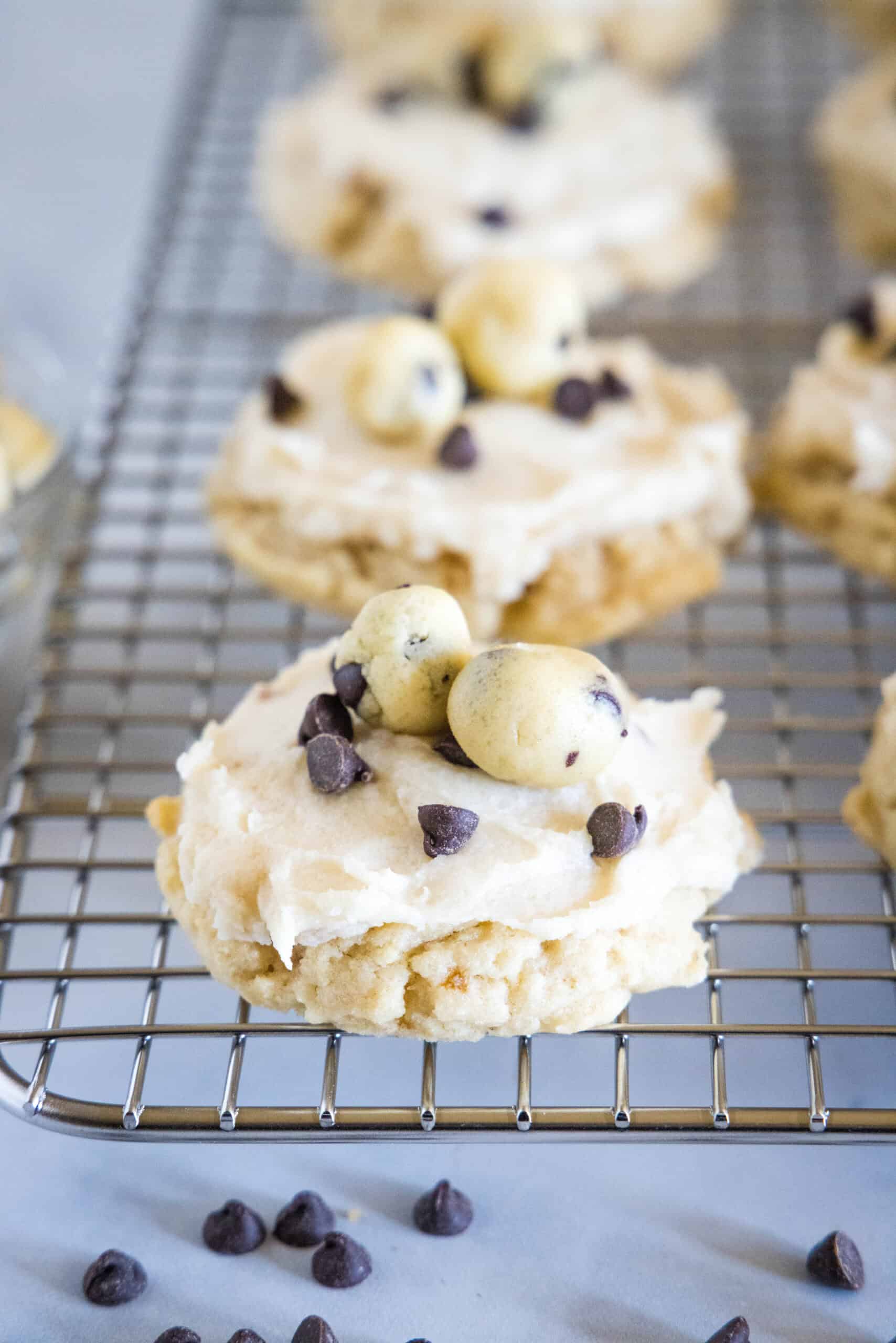 Frosted cookie dough cookies on a wire rack.