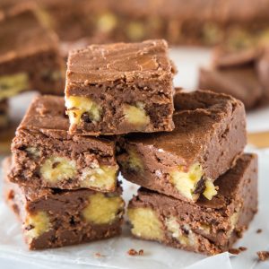 close up pieces of cookie dough fudge stacked on cutting board