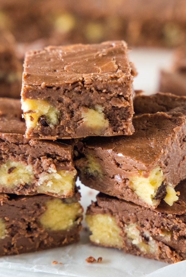 close up pieces of cookie dough fudge stacked on cutting board