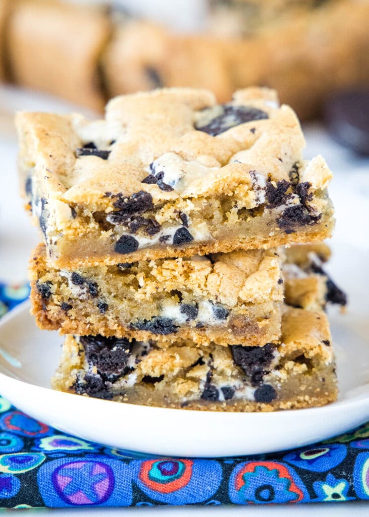 stacked cookies and cream bars on a white plate