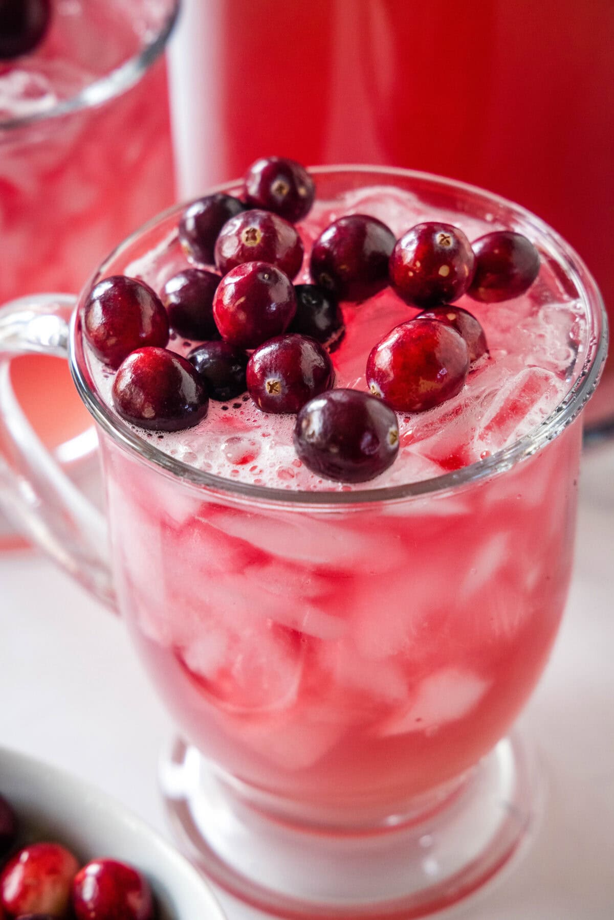 cranberry punch in a glass topped with cranberries