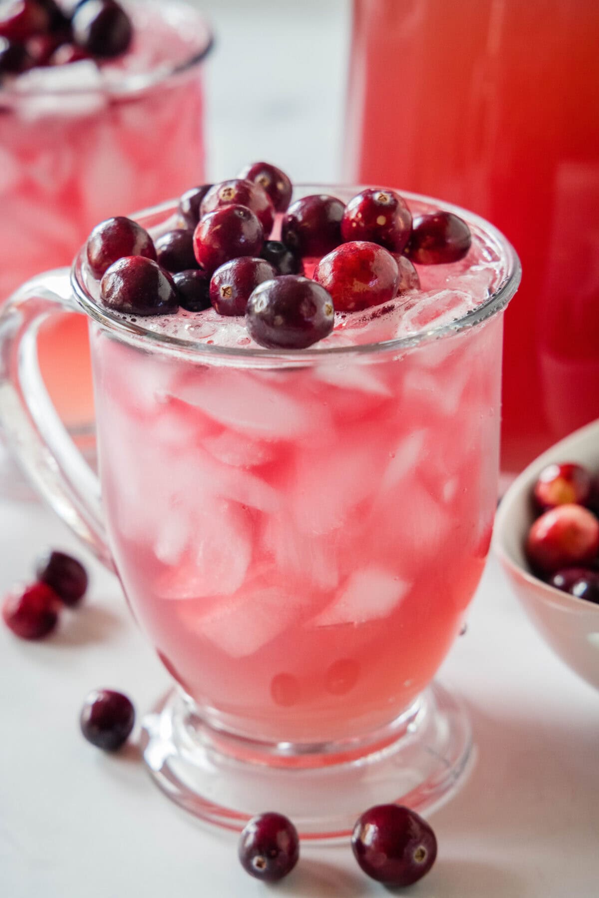 cranberry punch in a glass topped with cranberries