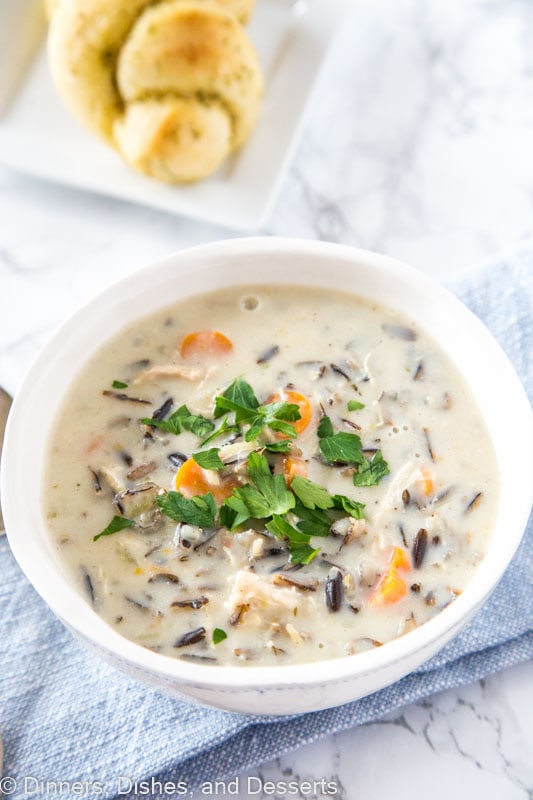 A bowl of food on a plate, with Soup and Wild rice