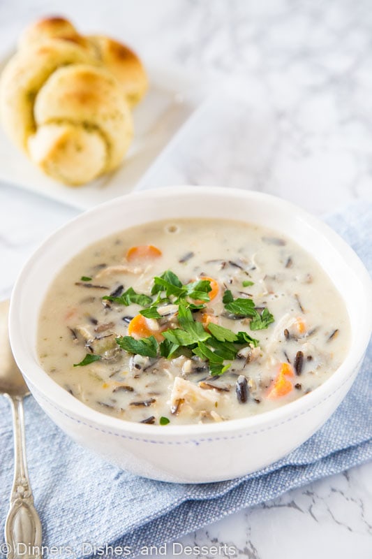 A bowl of food on a plate, with Soup and Wild rice