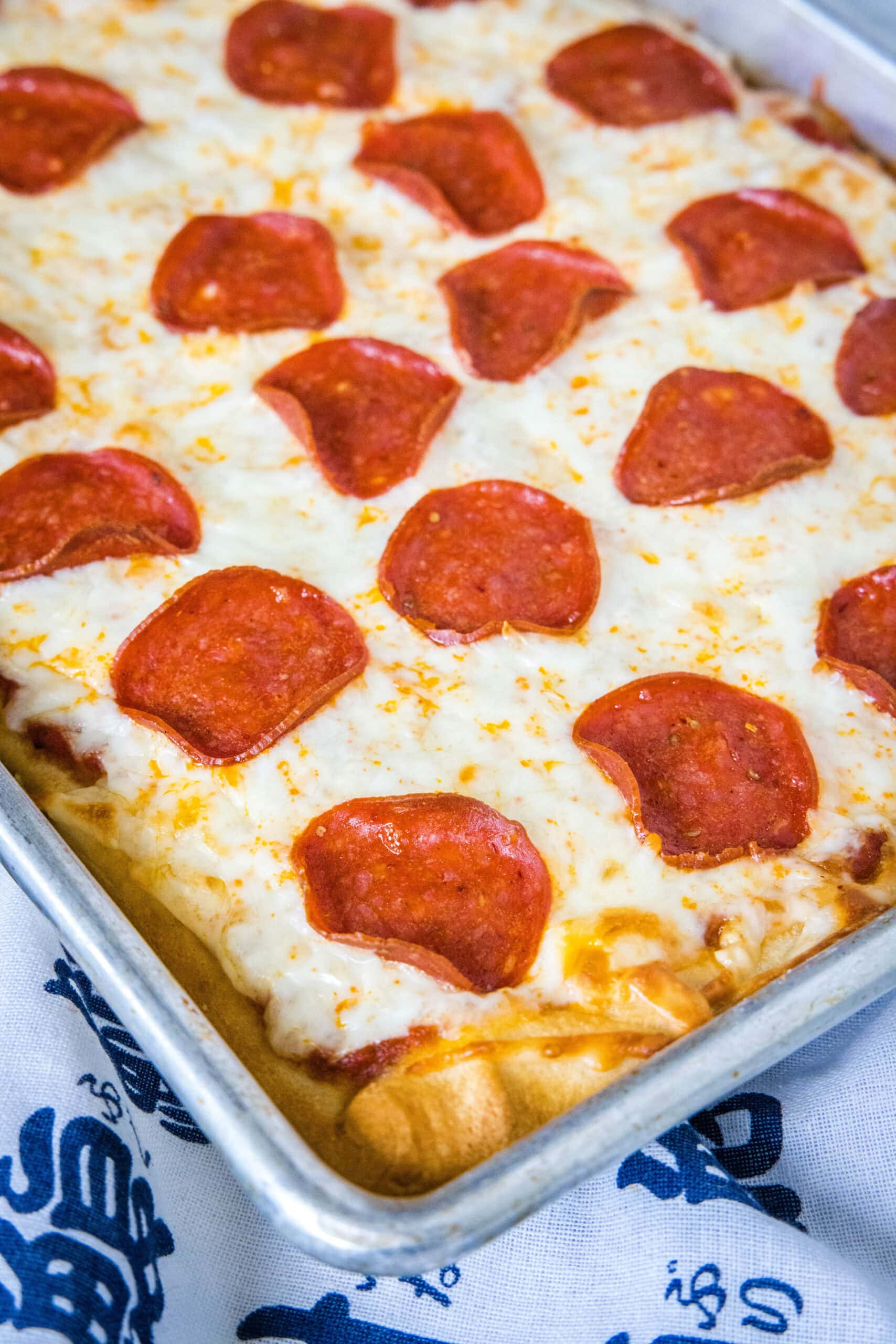 Pepperoni crescent roll pizza on a large rectangle baking sheet.