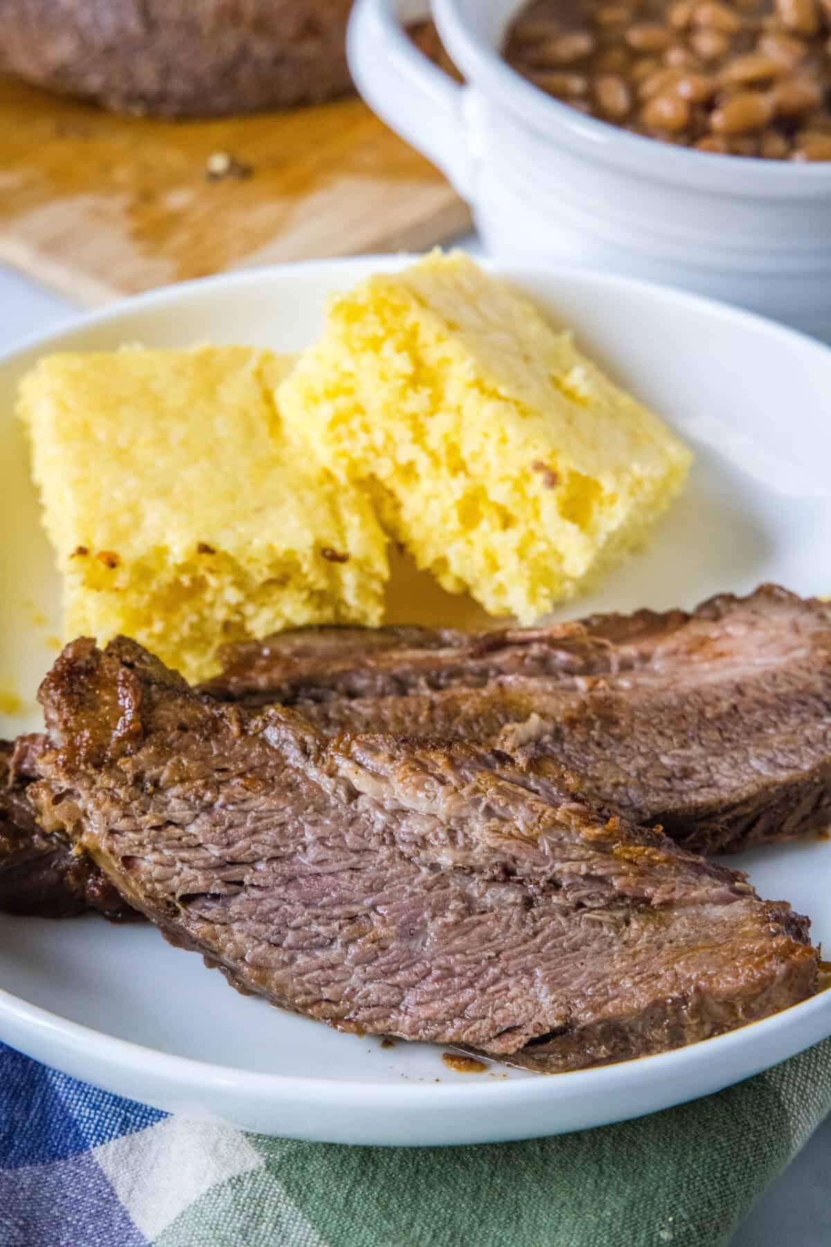 sliced brisket on a plate with cornbread