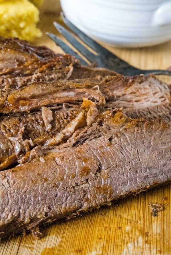 cropped close up sliced brisket on cutting board