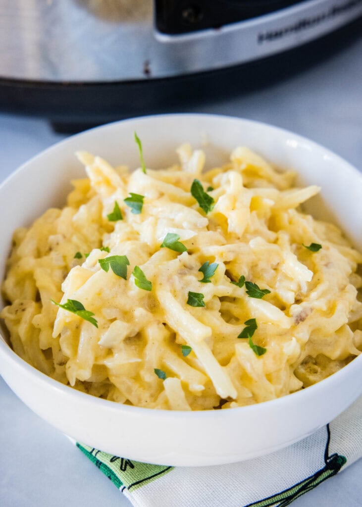 a white bowl of cheesy hashbrown casserole