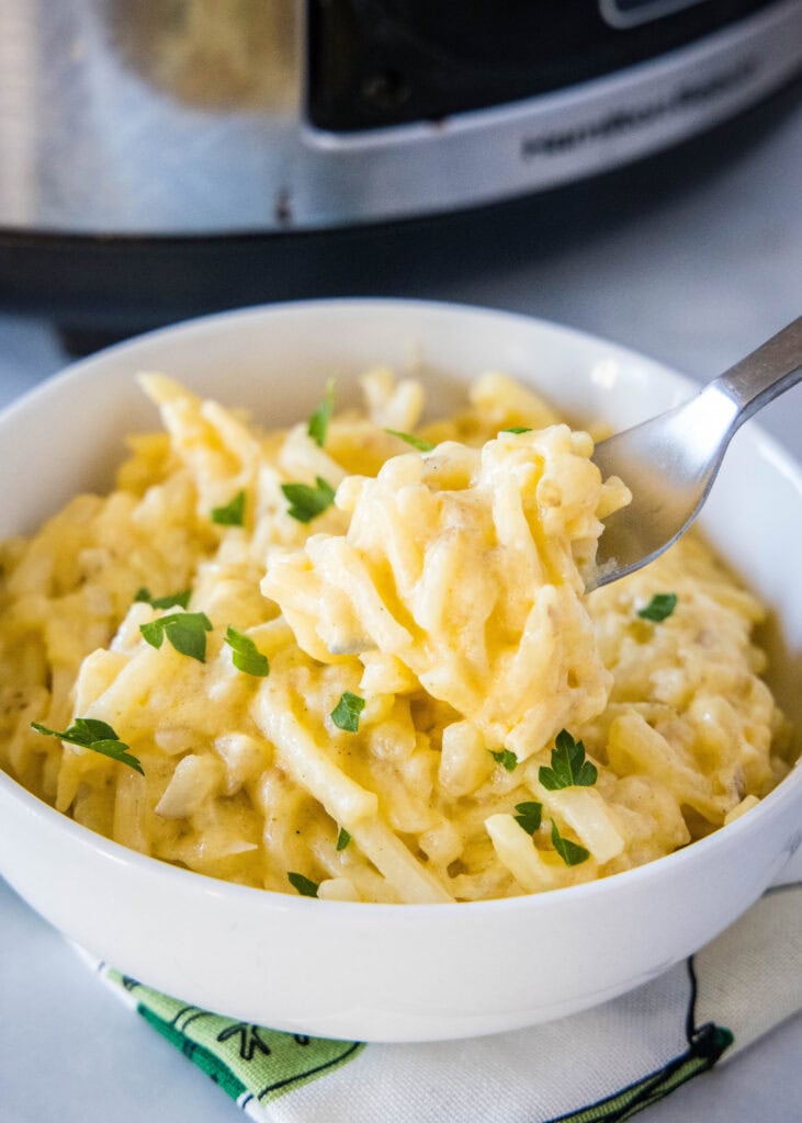 a forkful of cheesy hashbrown casserole