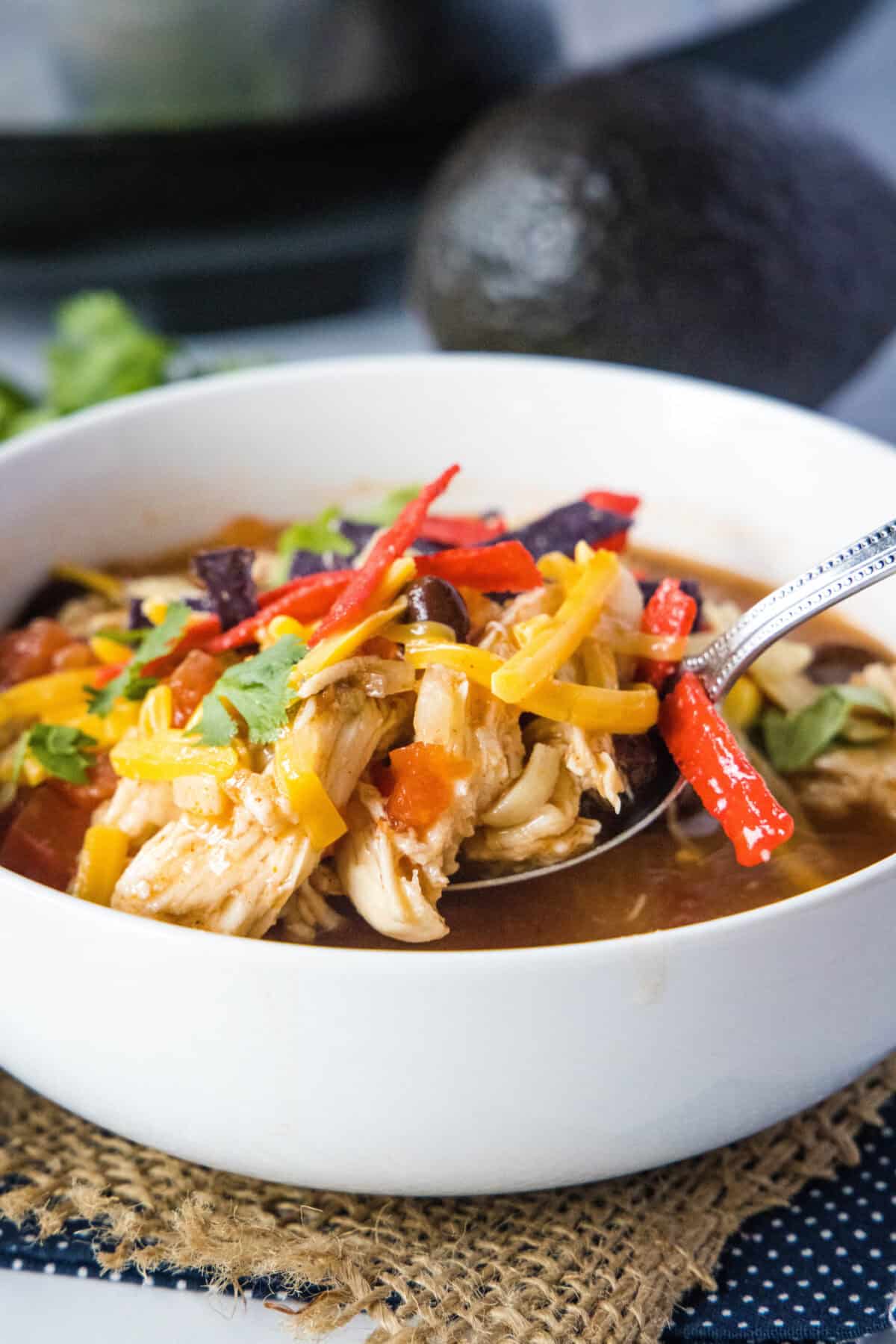 scooping a bite of chicken tortilla soup out of bowl