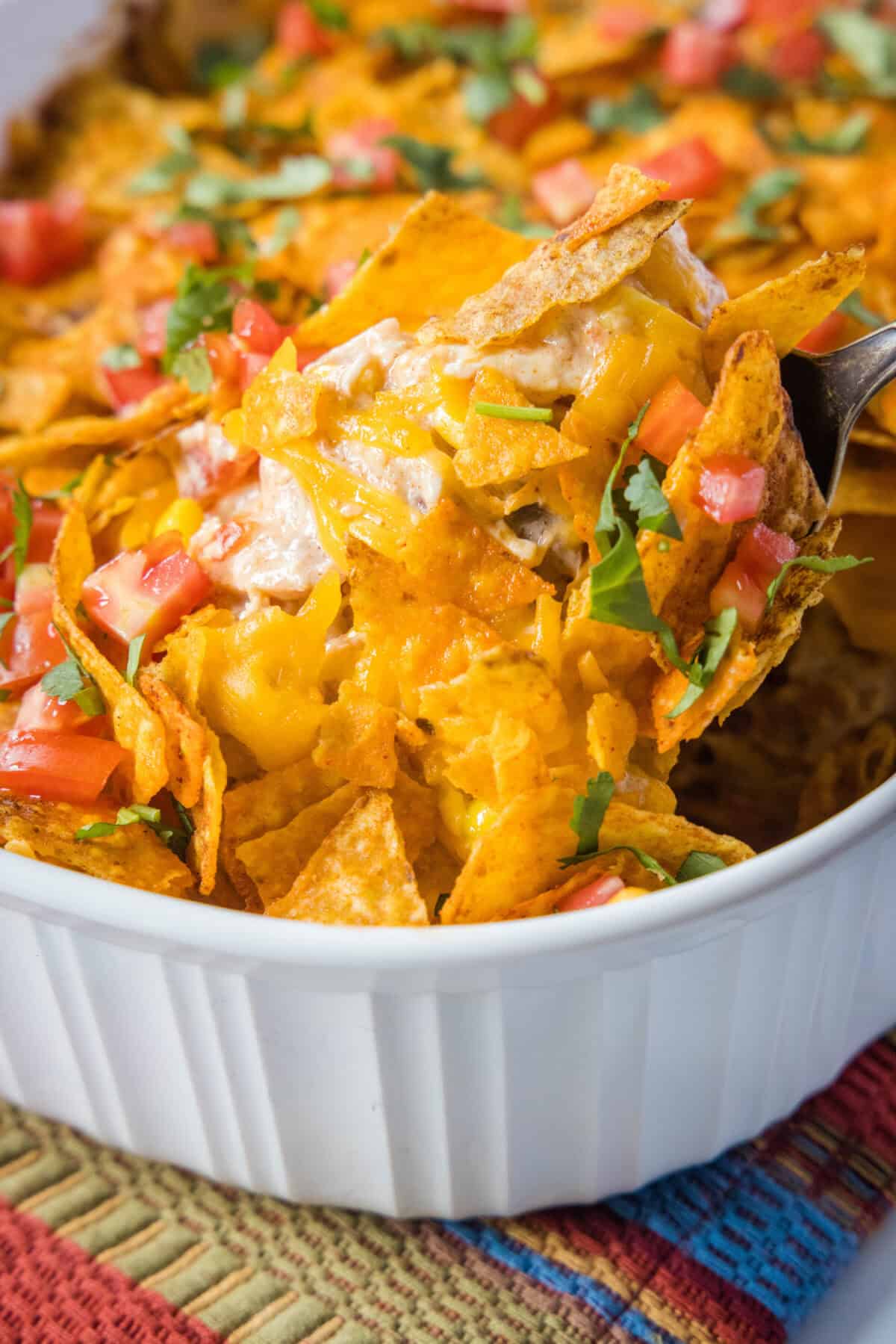 scooping dorito chicken casserole from baking dish