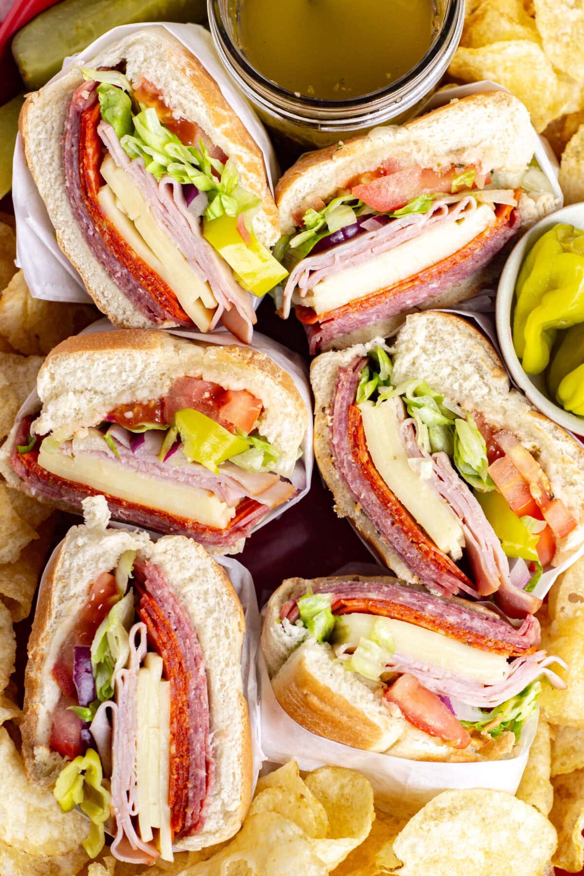 looking down on italian subs and potato chips on a platter