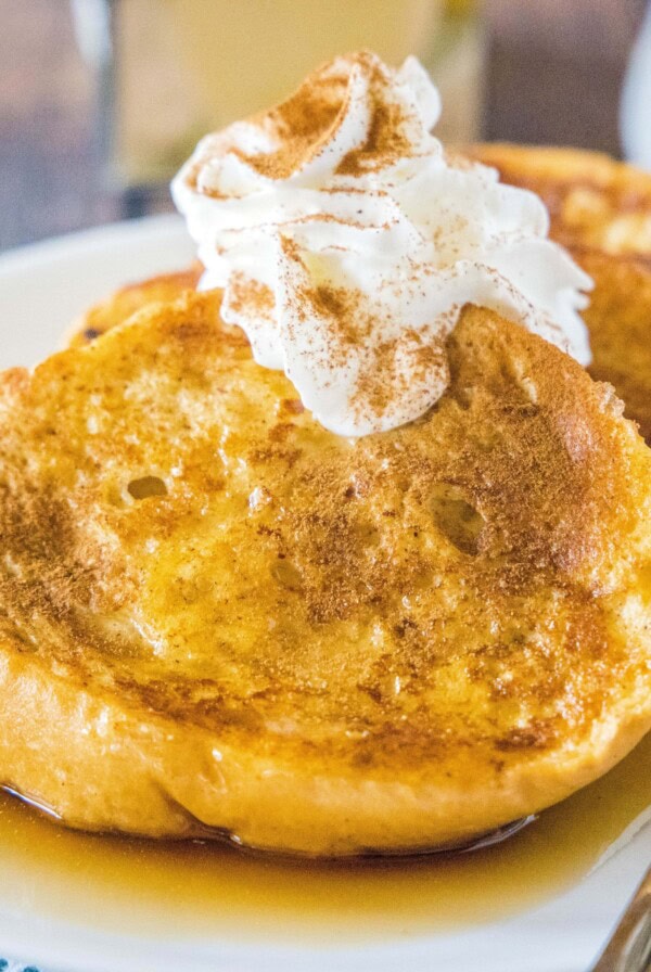 cropped plate of french toast with whipped cream and cinnamon on top