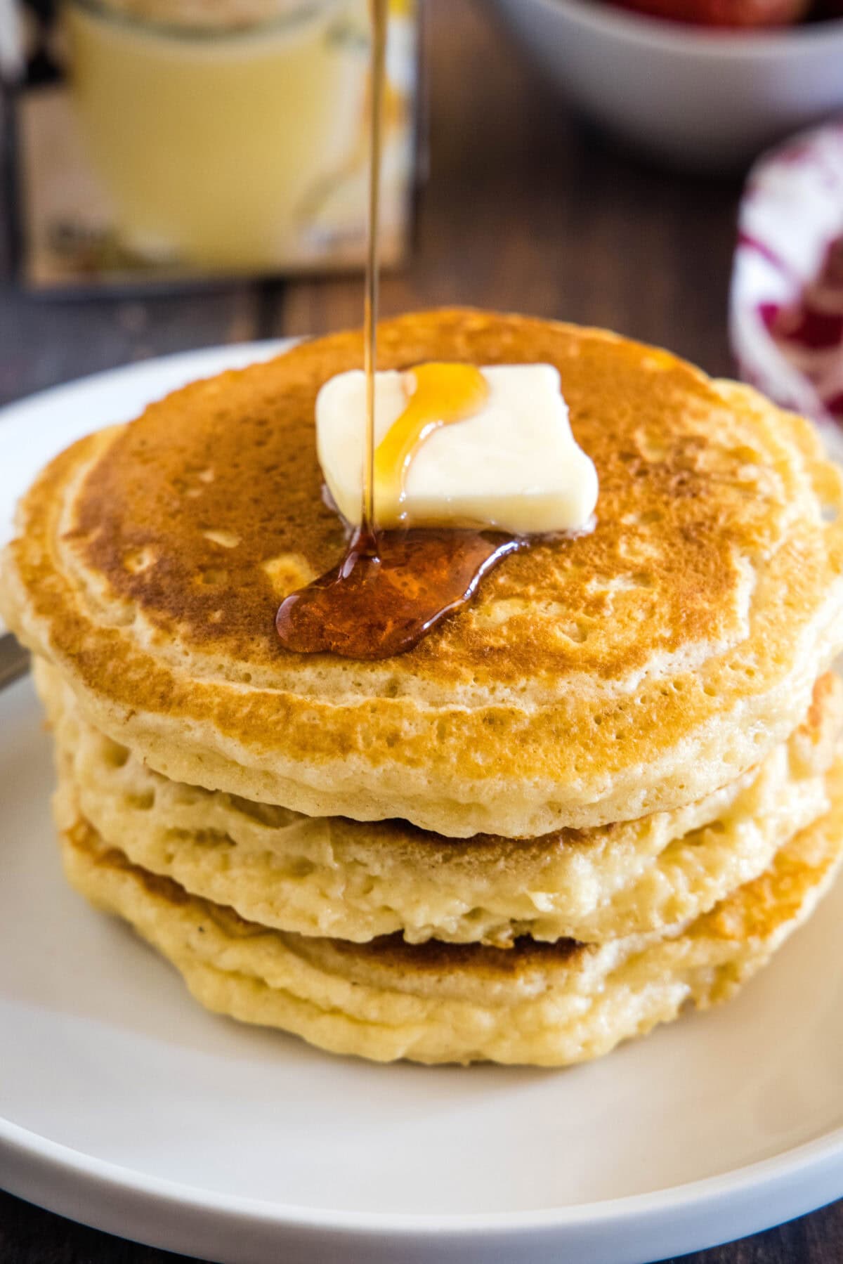 pouring syrup on eggnog pancakes