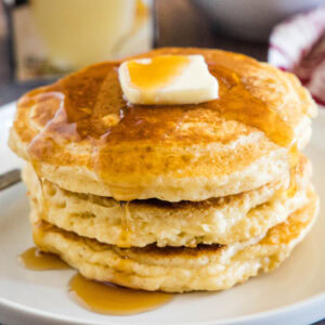 close up stack of eggnog pancakeson a white plate