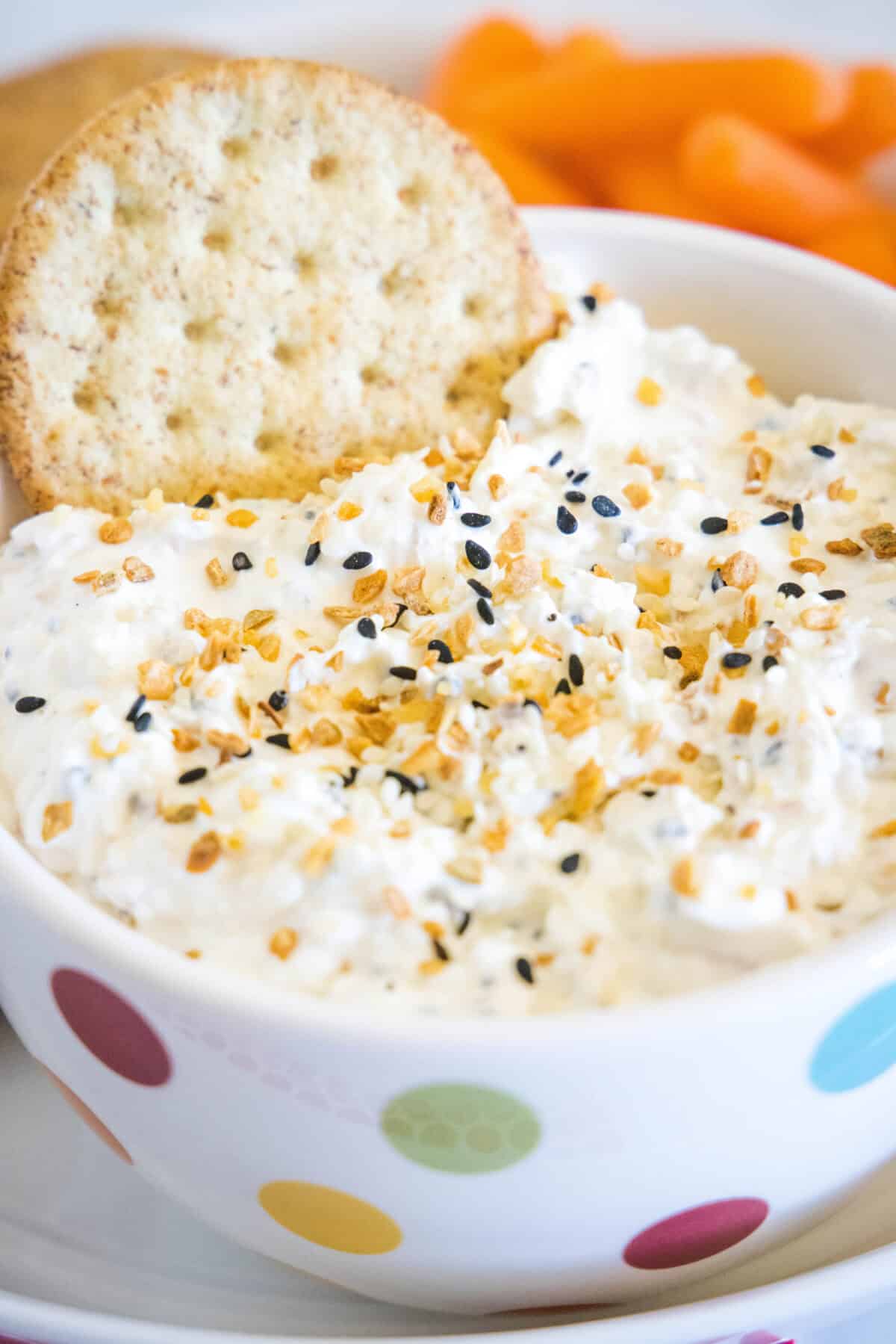 everything bagel dip in a bowl with a cracker