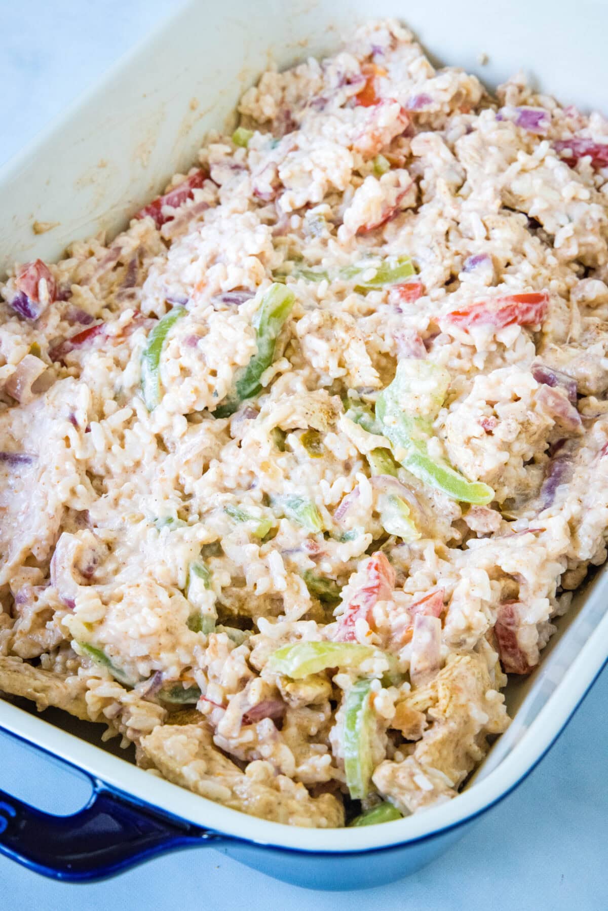 Chicken fajita casserole filling spread evenly in a baking dish.
