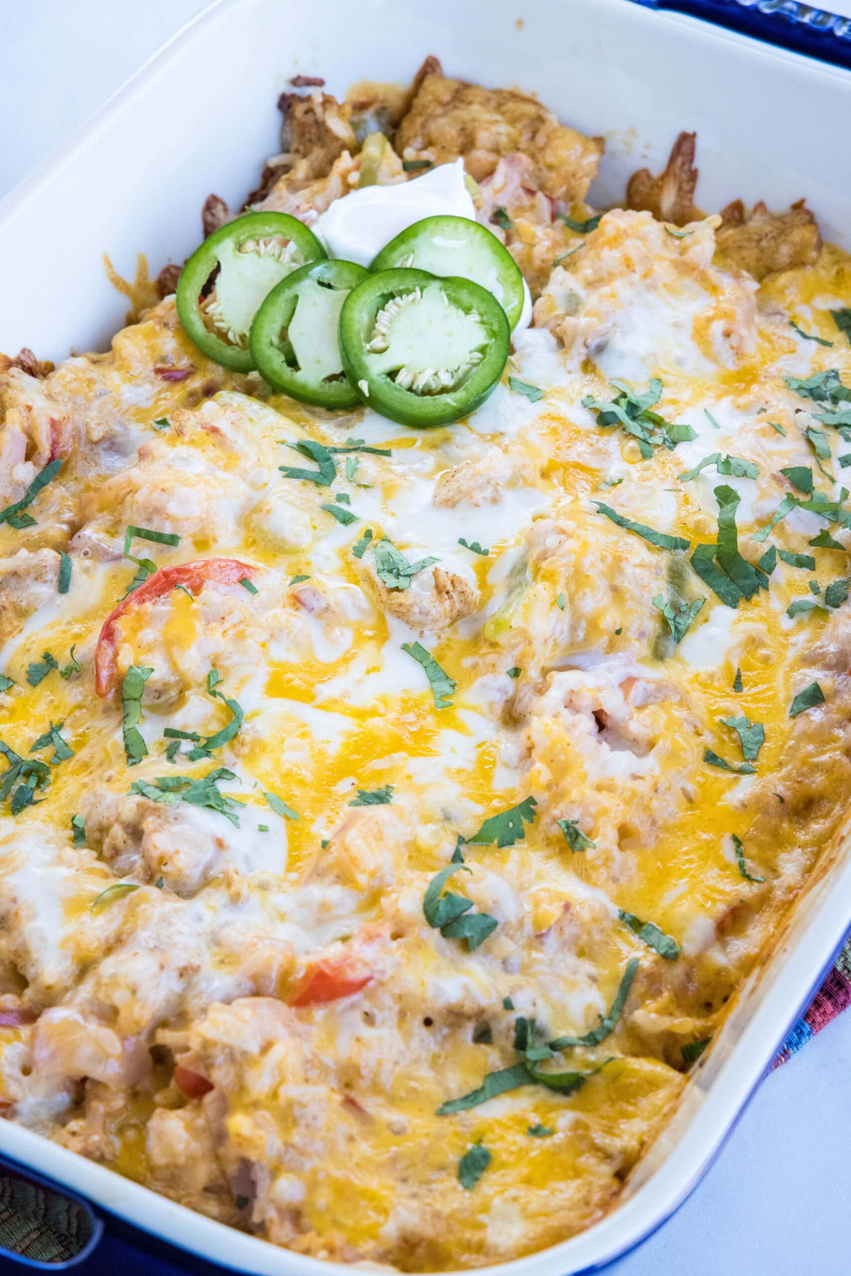 Baked chicken fajita casserole garnished with sliced jalapeños in a baking dish.