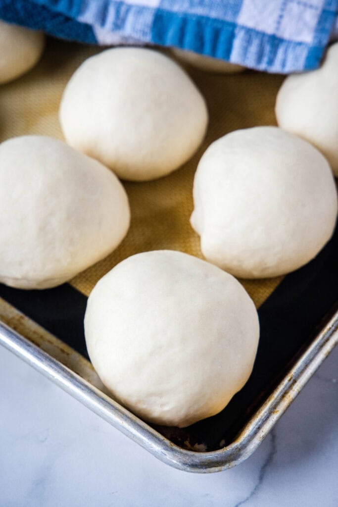 rolls after rising on a baking sheet