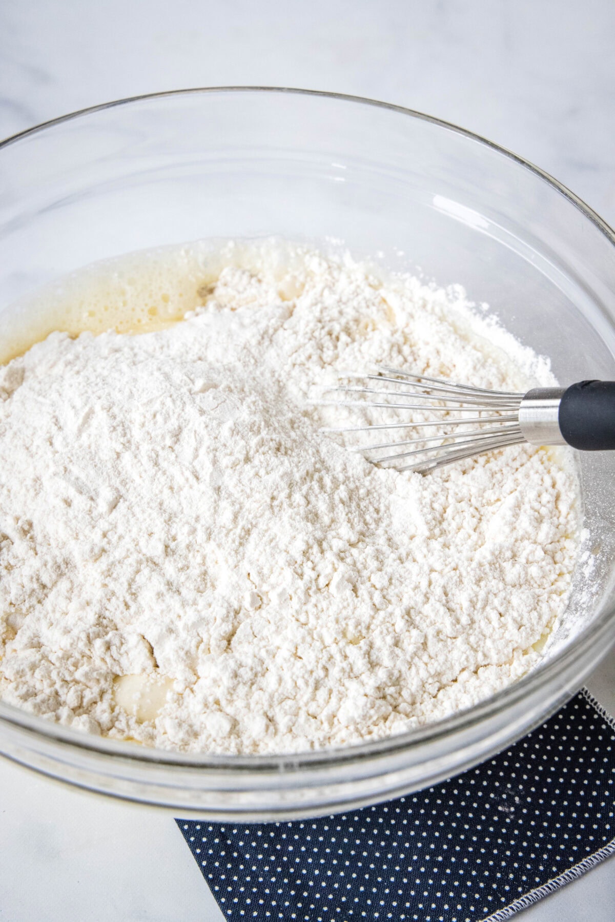 Griddle cake batter ingredients combined in a glass mixing bowl.