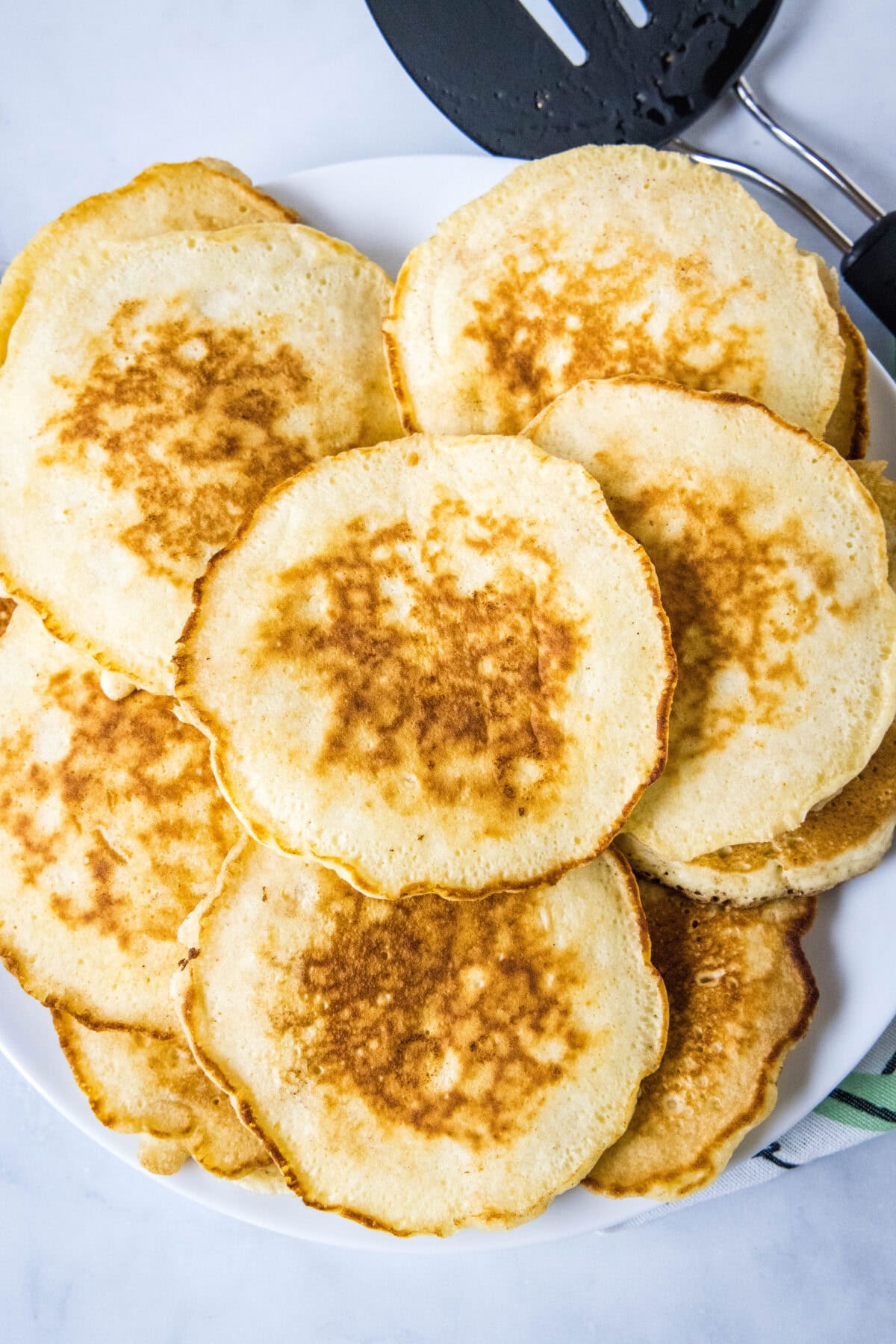 Overhead view of griddle cakes stacked on a a platter.