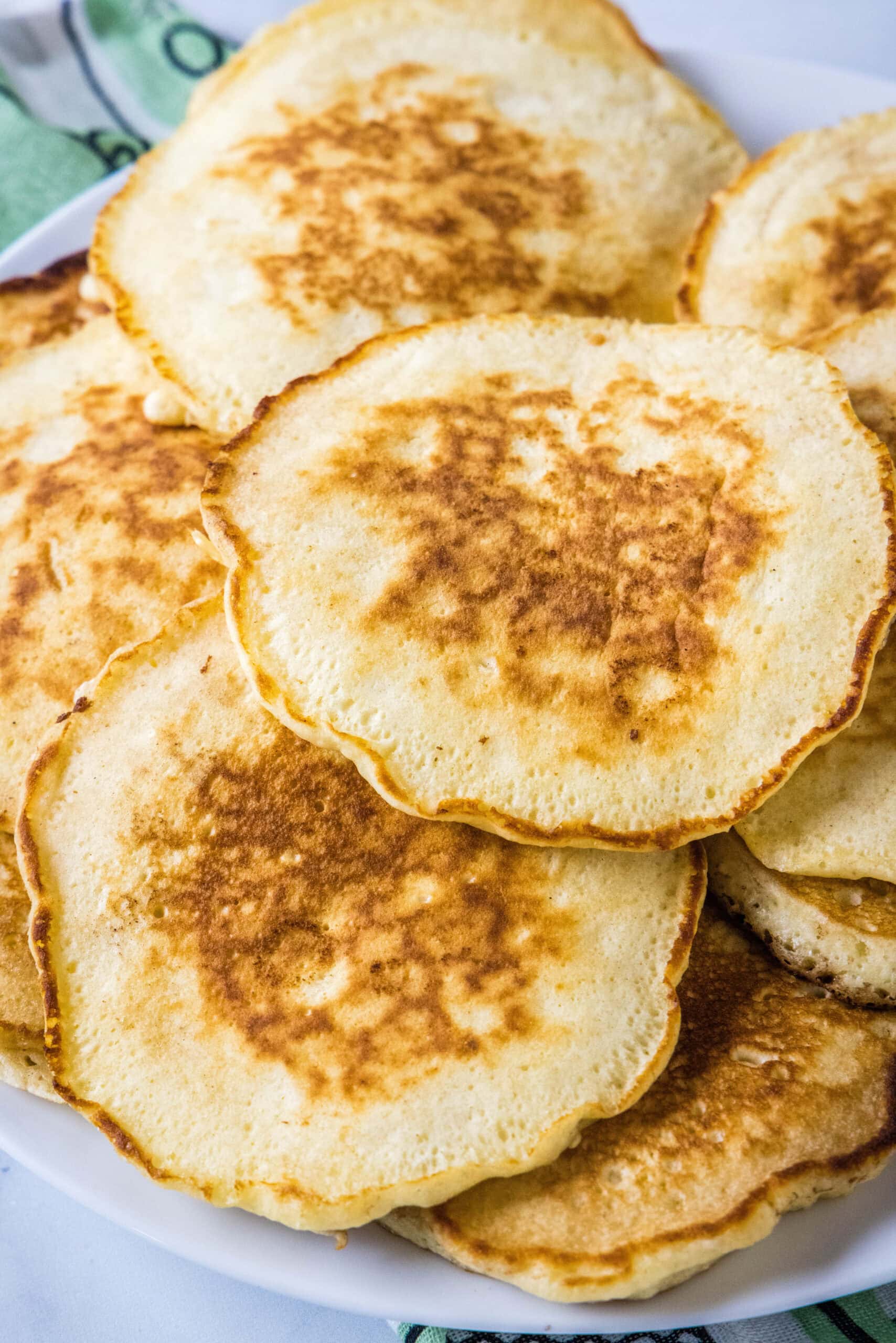 Overhead view of griddle cakes stacked on a a platter.