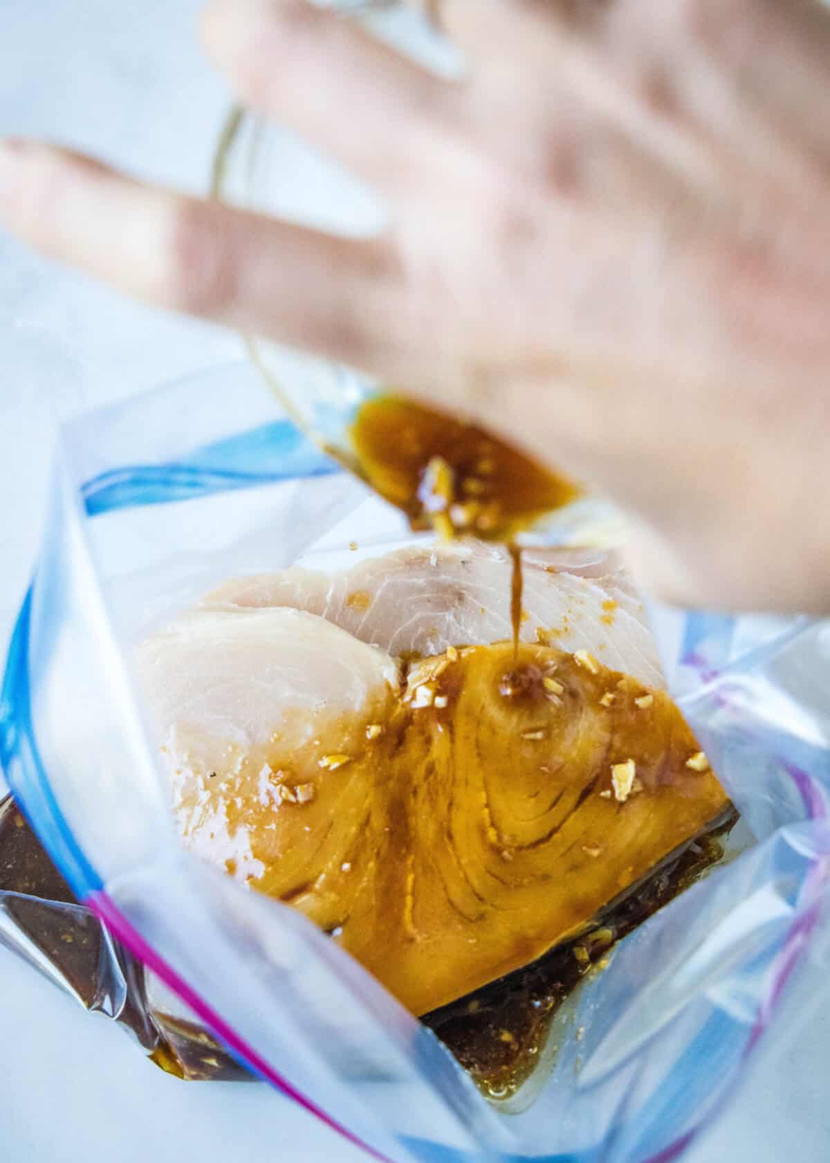 pouring swordfish marinade into bag