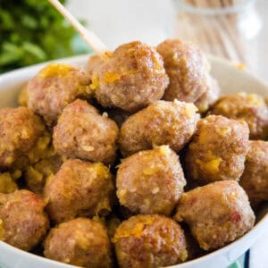 Ham balls with pineapple sauce piled into a bowl.