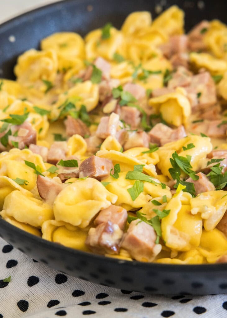 Ham tortellini in a large skillet.