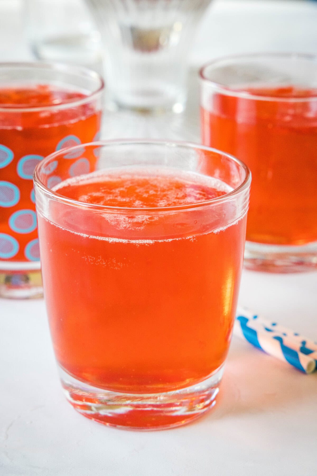 A glass of holiday punch with more filled glasses in the background.