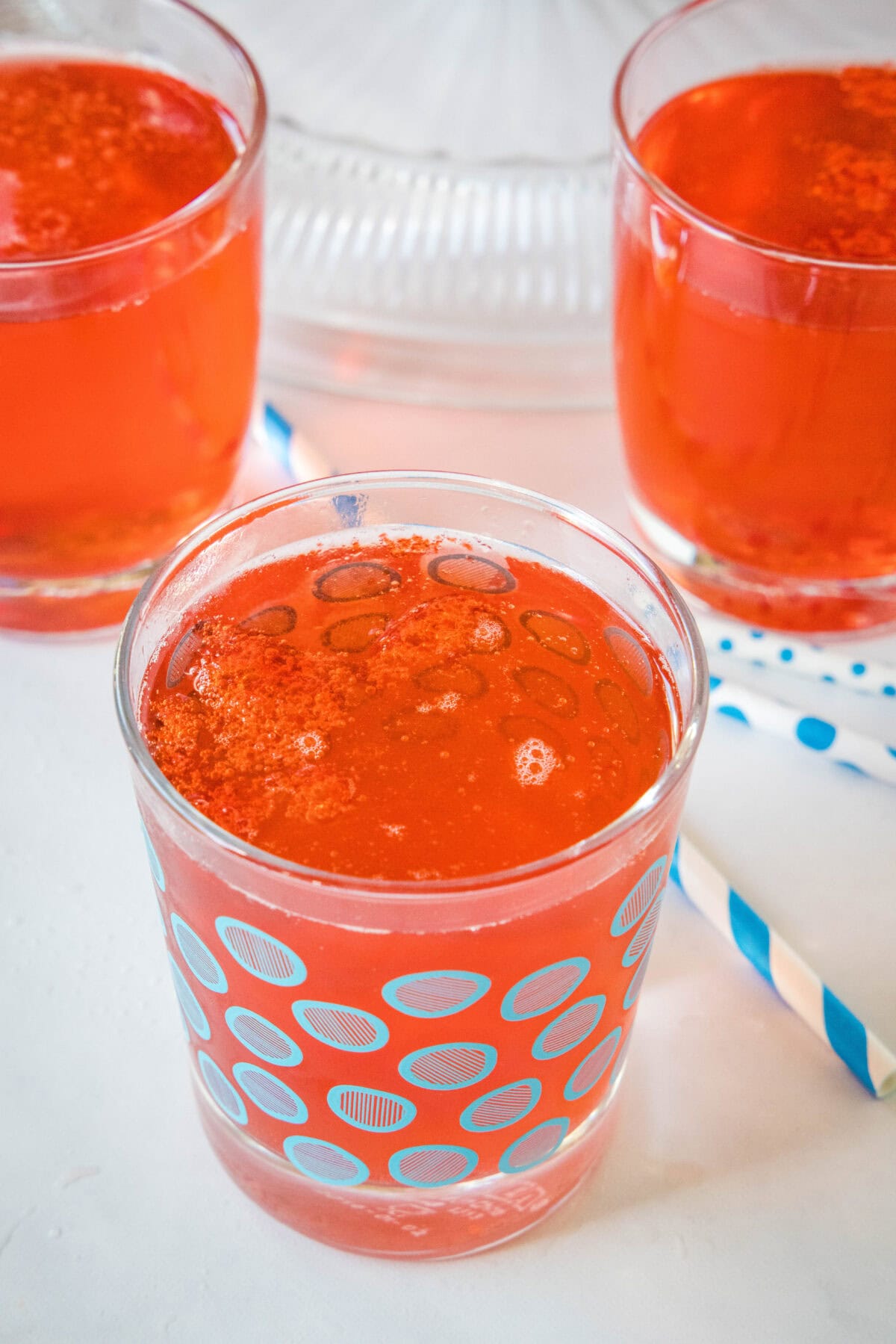 A glass of holiday punch with more filled glasses in the background.