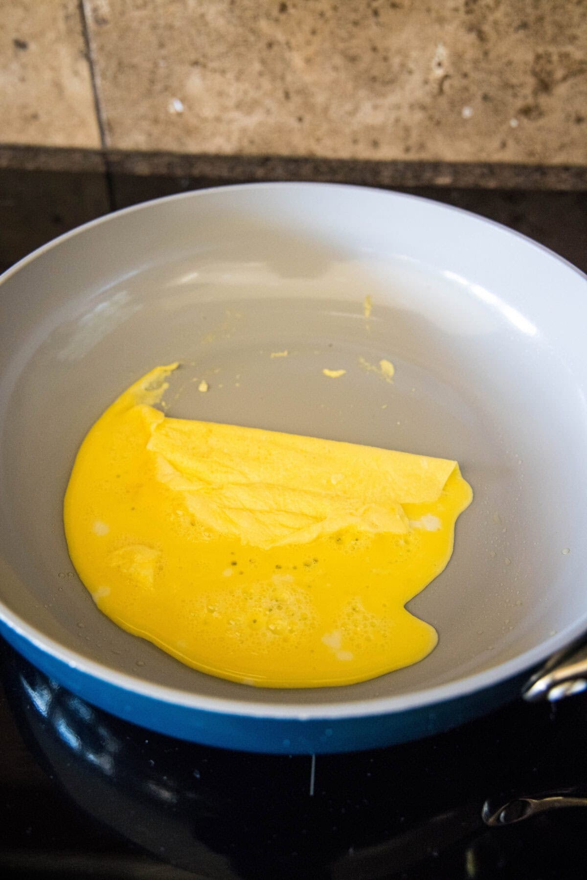 folding eggs into thirds in a skillet