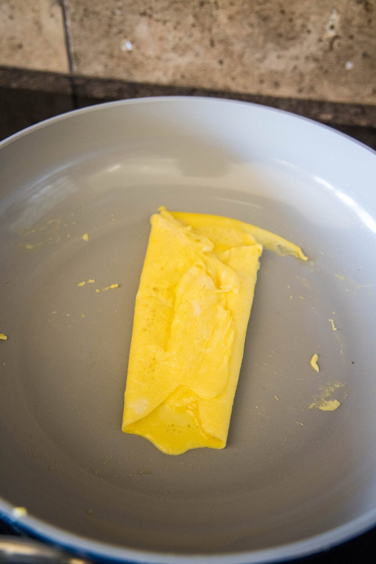 folding eggs into thirds in a skillet