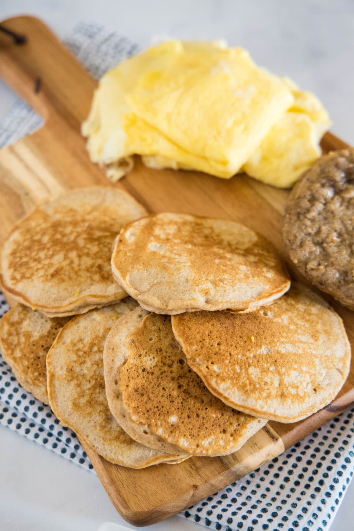 pancakes sausage and eggs on a cutting board