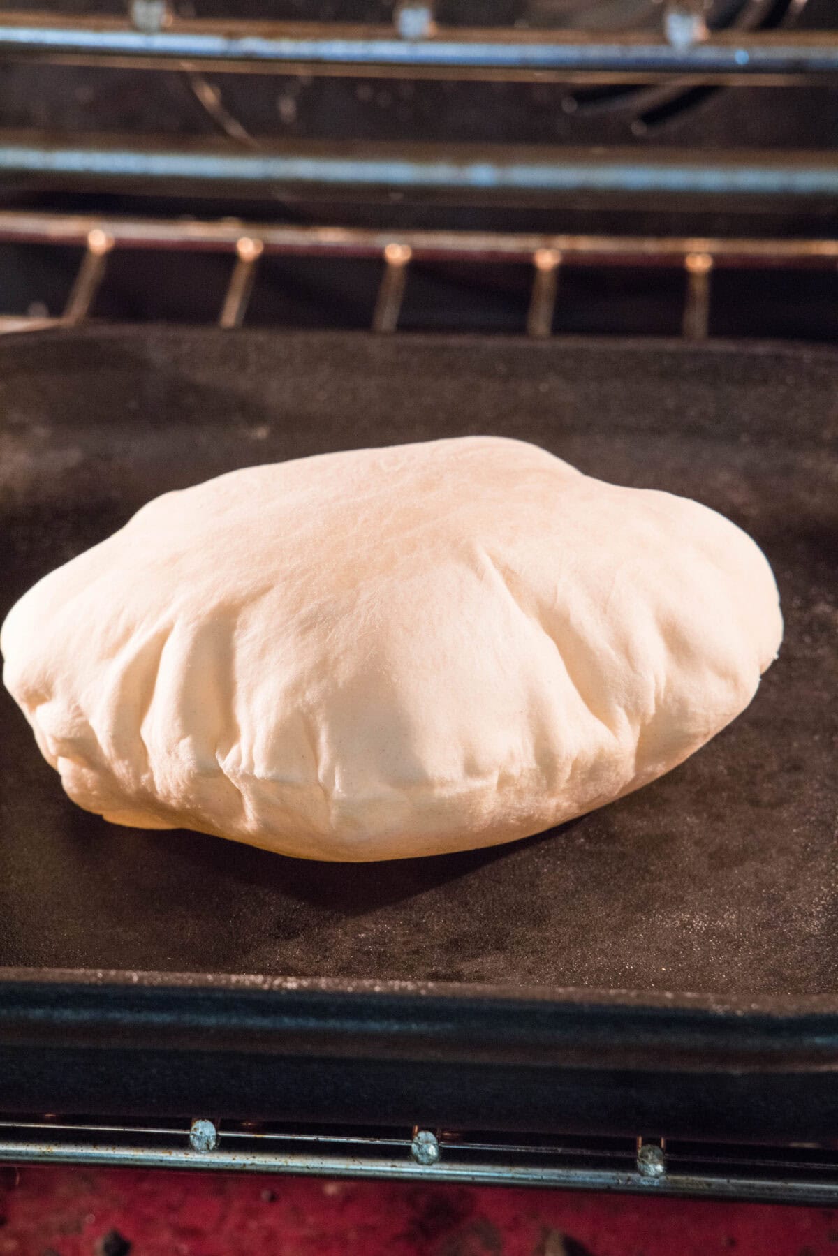 A pita puffing up on a hot pan.
