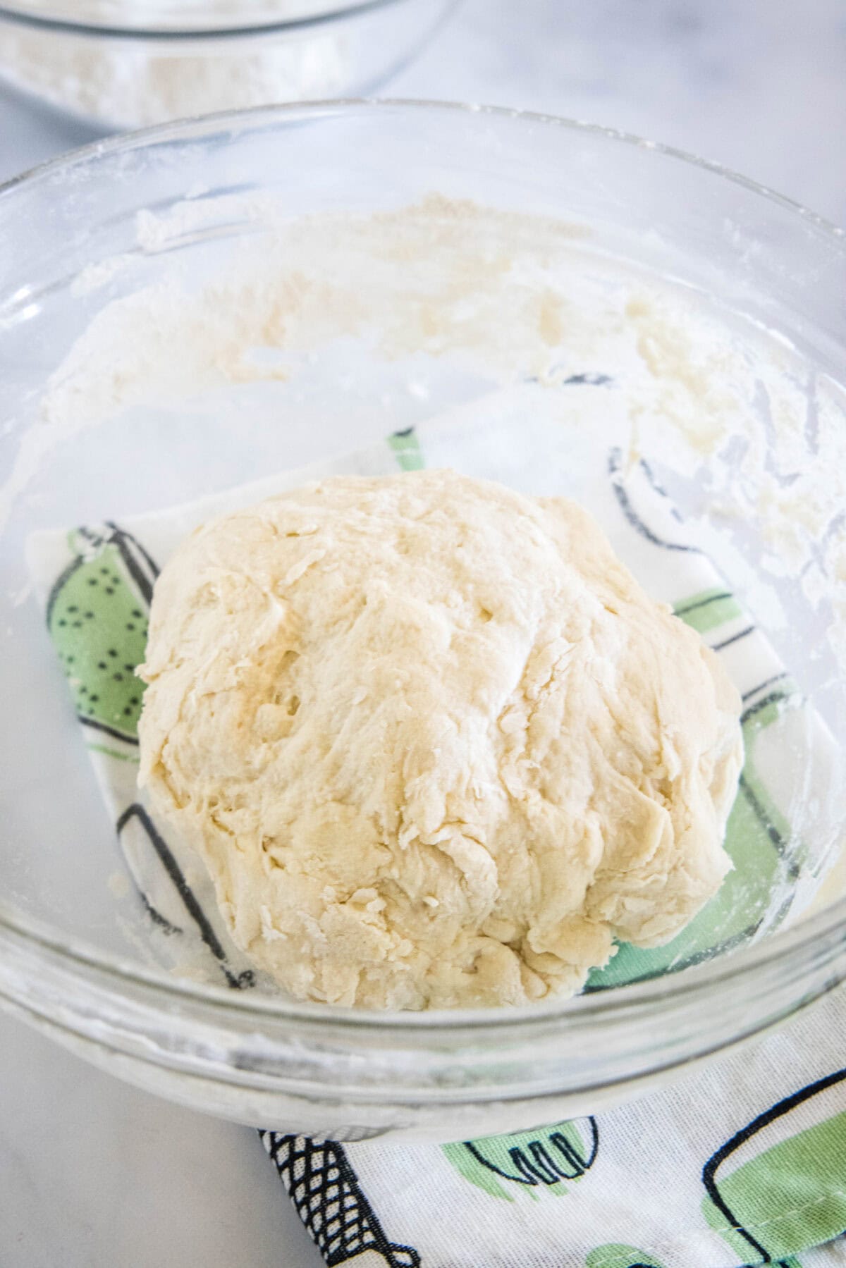 Pita dough in a glass bowl.