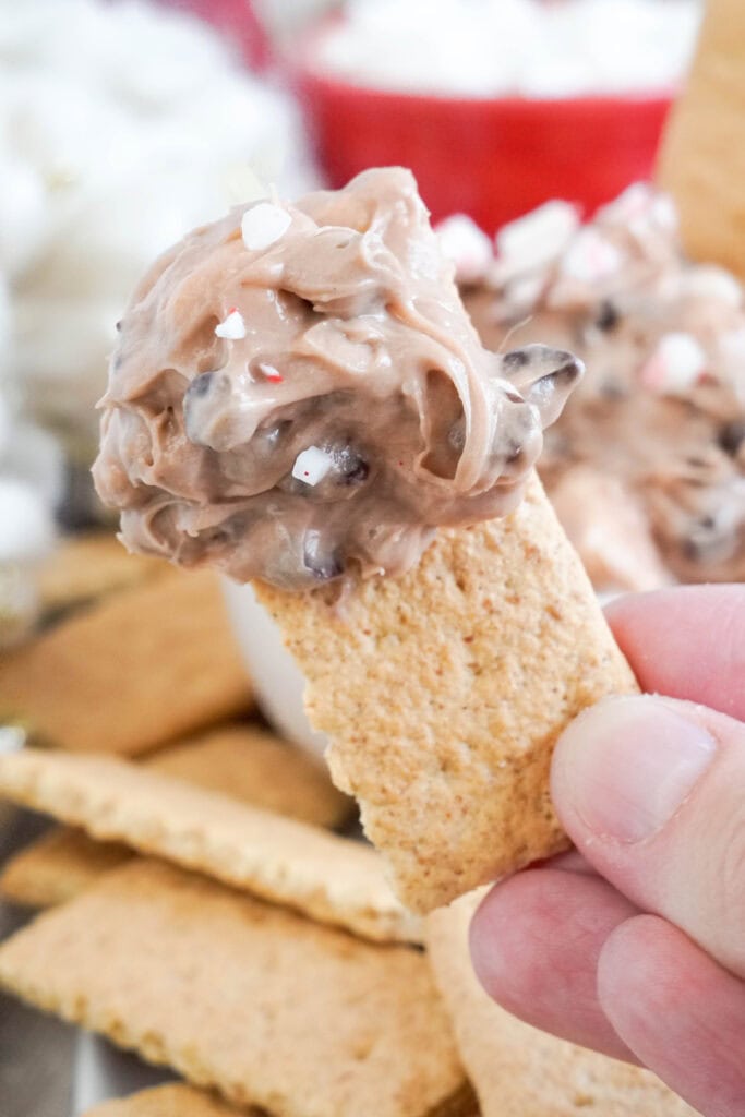 scooping hot chocolate dip onto a graham cracker