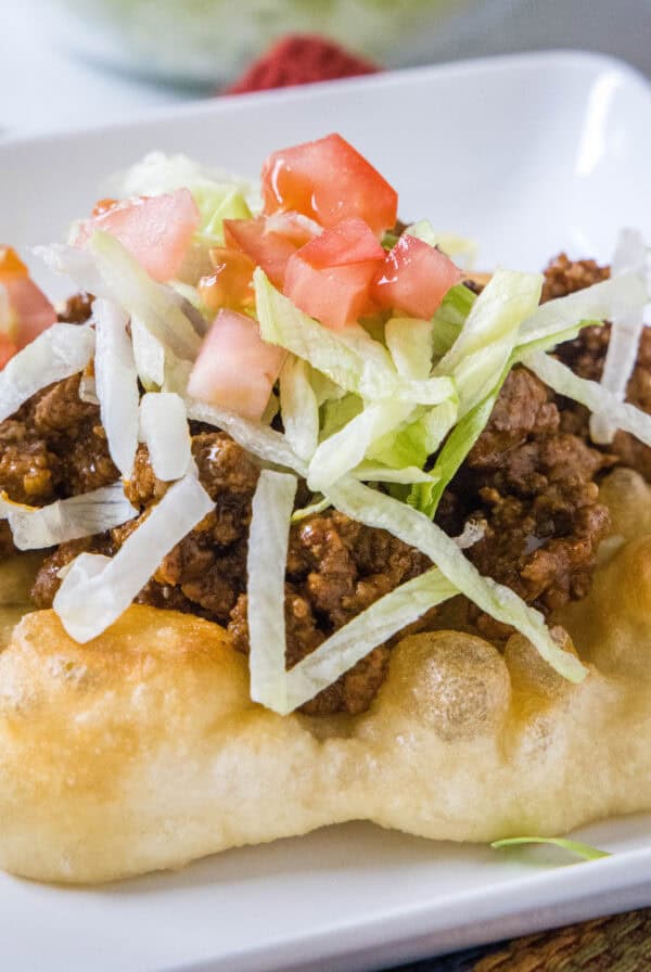 cropped close up indian fry bread taco on a white plate