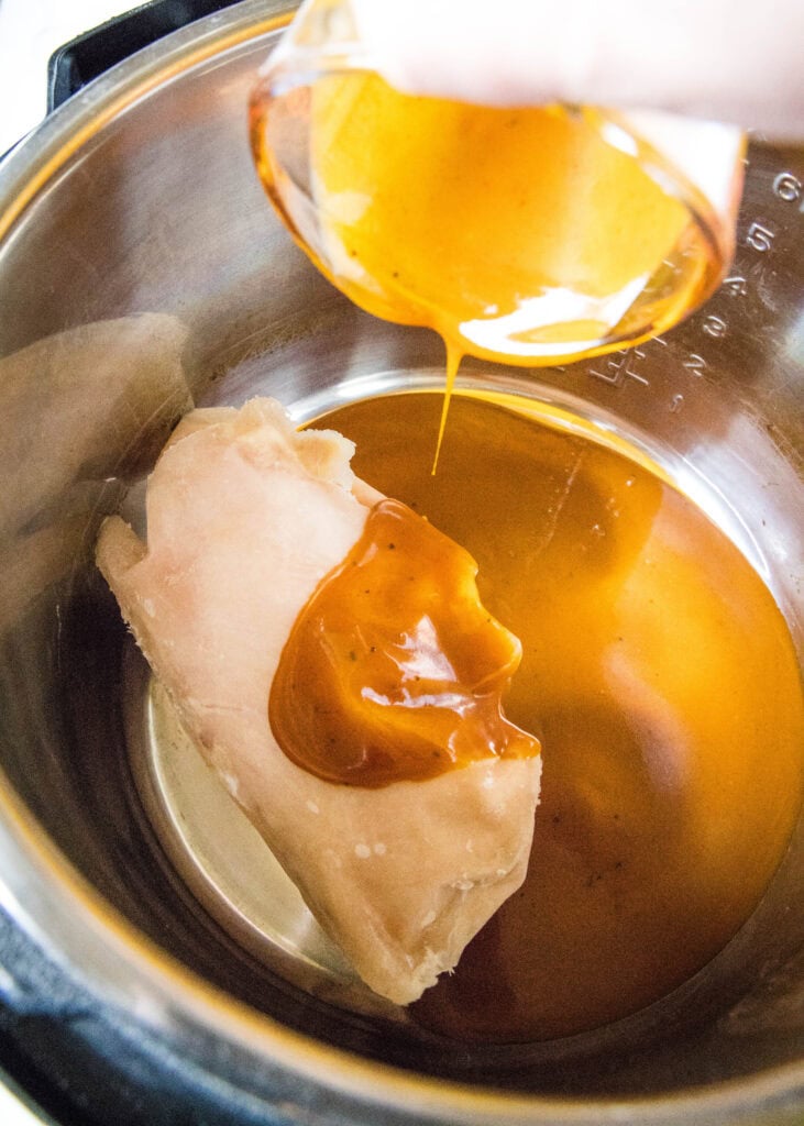 pouring sauce over chicken