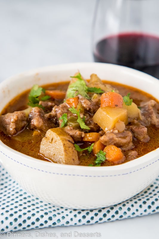 A bowl of food on a plate, with Stew and Beef