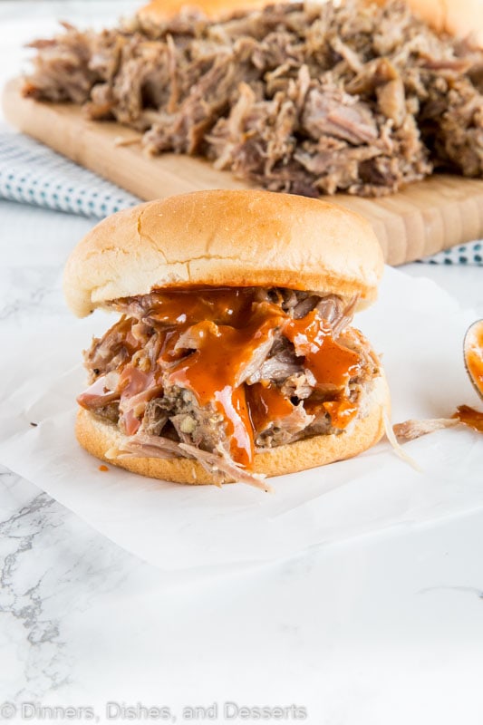 A sandwich sitting on top of a paper plate, with Pork and Dinner