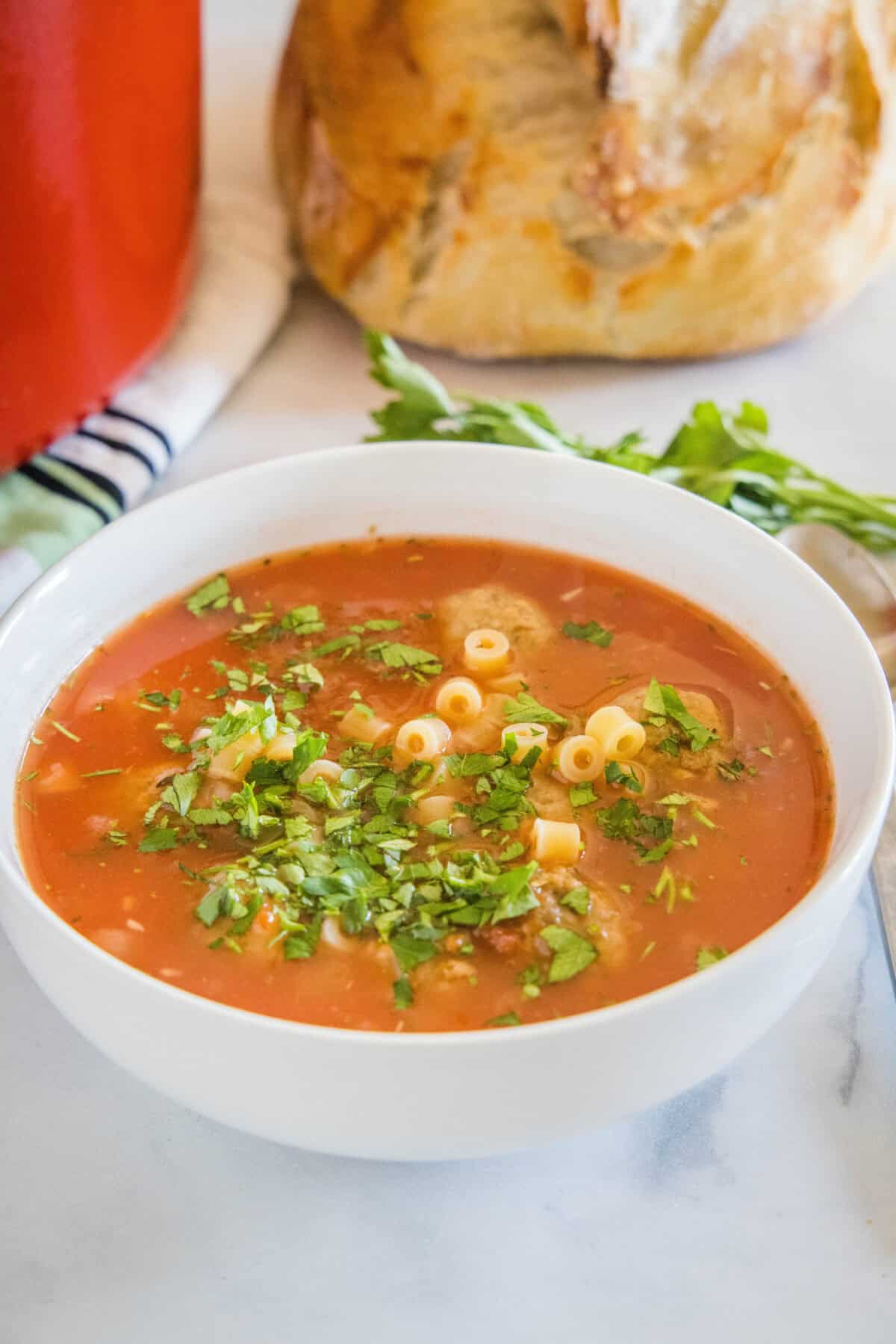 italian meatball soup topped with parsley