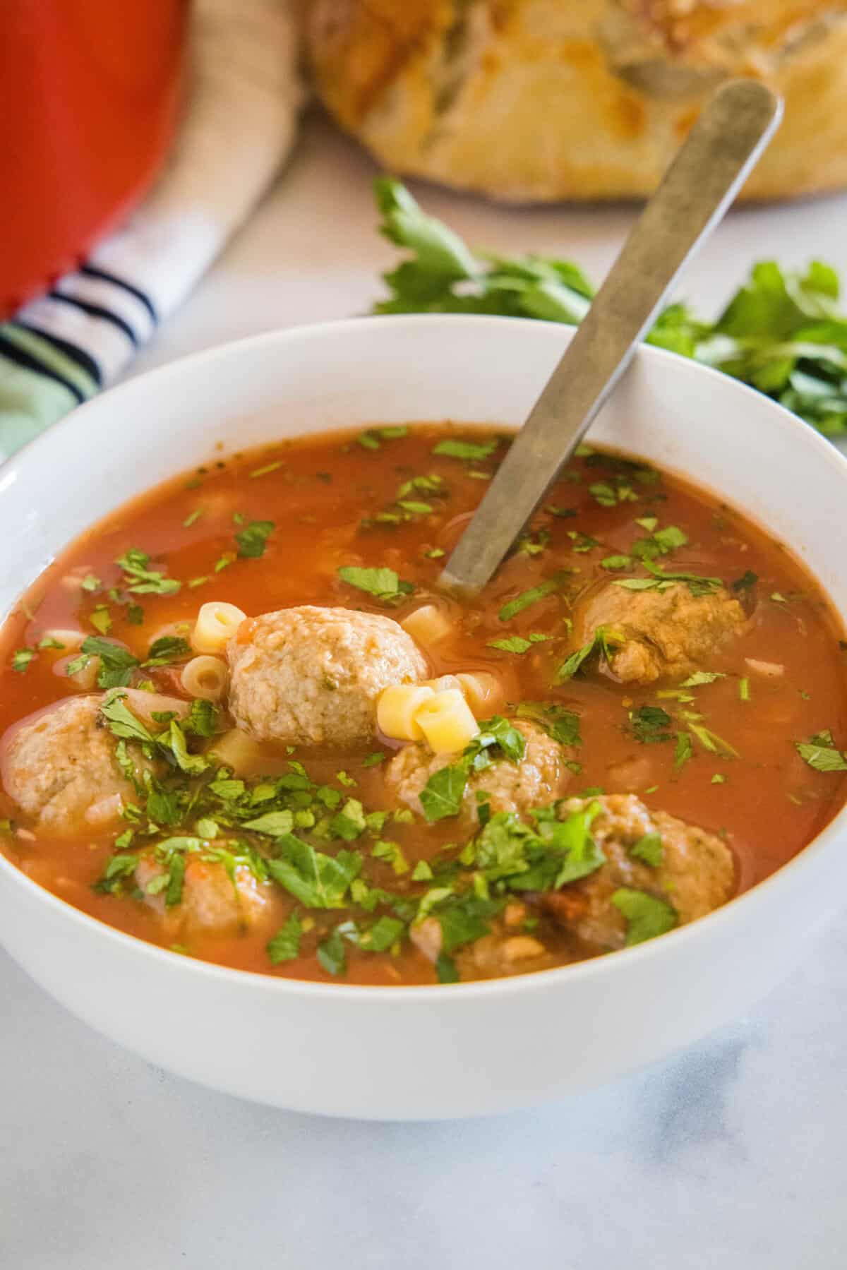 bowl of italian meatball soup with a spoon