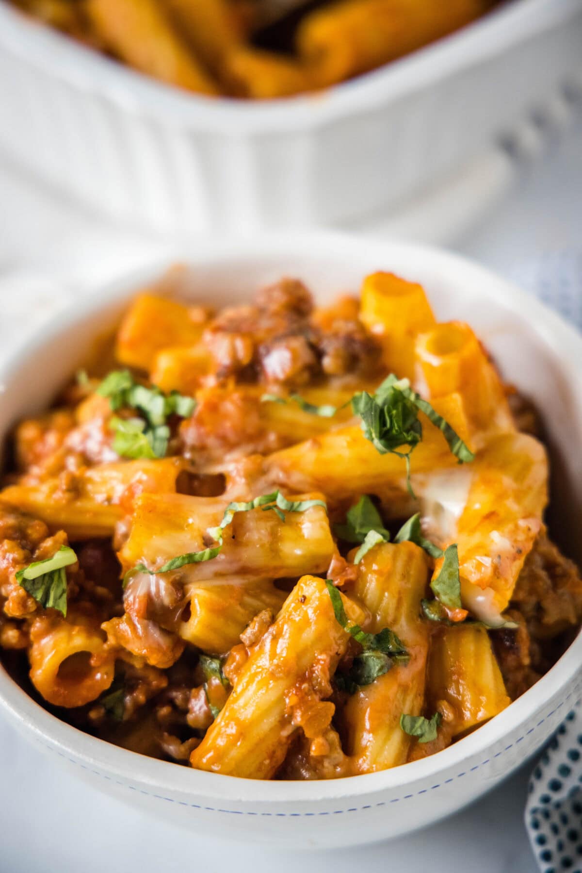 italian sausage casserole in a bowl with fresh basil