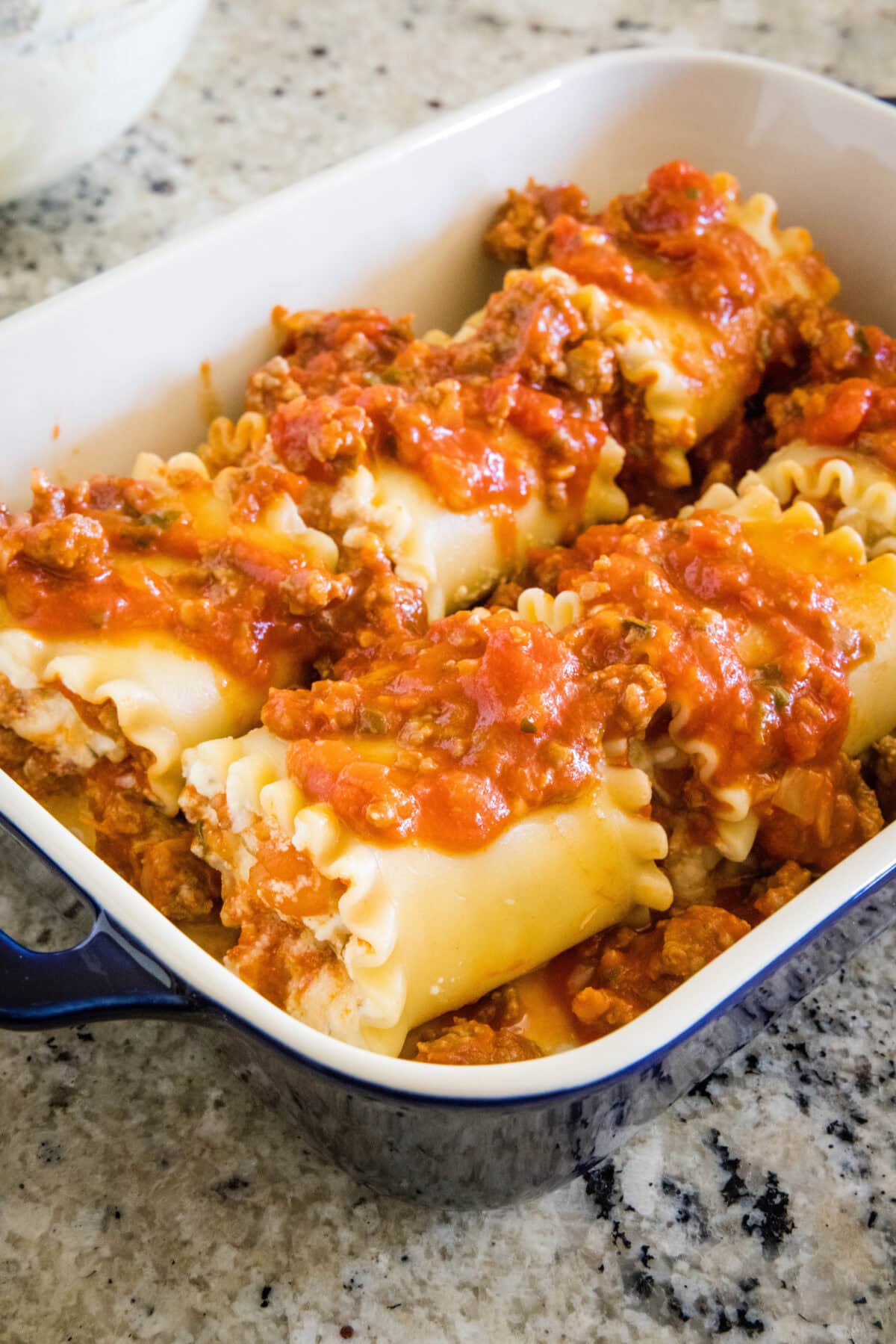 Lasagna roll ups assembled in a baking dish.