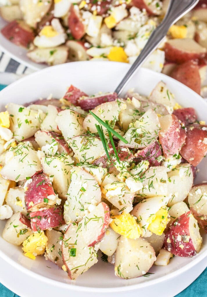 lemon herb potato salad in a white bowl
