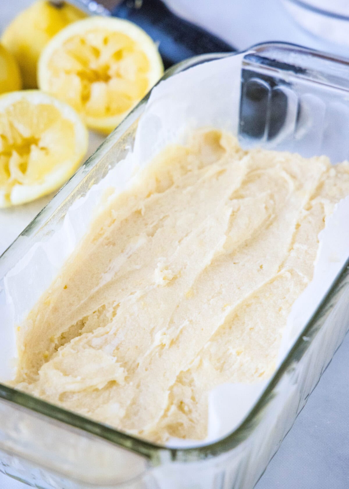 Lemon bread batter inside a glass loaf pan.